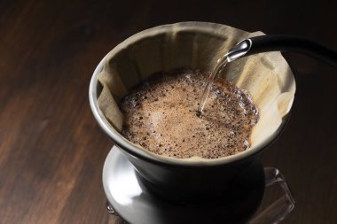 Kahve tozunun üzerine sıcak su dök.