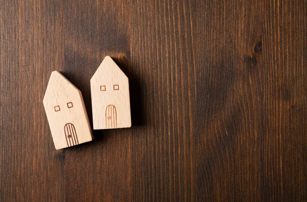 Toy house made of wood placed on a wooden background with copy space. View from above