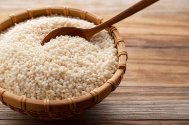 Bambu kevgire batırılmış glutinous pilavı fotokopi alanı olan ağaçların arka planına karşı.