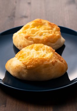 Arka planda tahta bir masanın üzerine yerleştirilmiş Fransız ekmeği. Japon Ekmeği