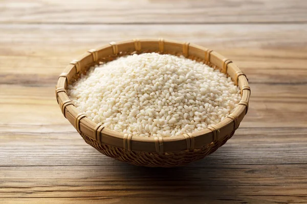 Glutinous rice in a bamboo colander set against a background of trees with copy space