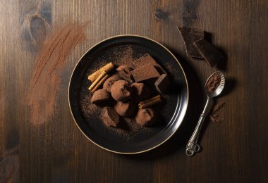 Kakao tozu ve tarçınlı çikolatalı mantarlar ahşap arka planda. Yukarıdan görüntüle