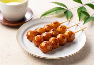 Mitarashi dango ve yeşil çay bir beze konur. Japon tatlısı, mitarashi dango.