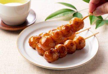 Mitarashi dango ve yeşil çay. Birini elimle kaldırıyorum.