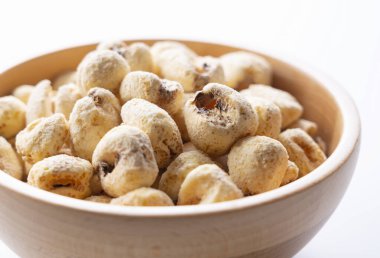 Beyaz arka planda ahşap bir kasede büyük boy mısır ürünleri.