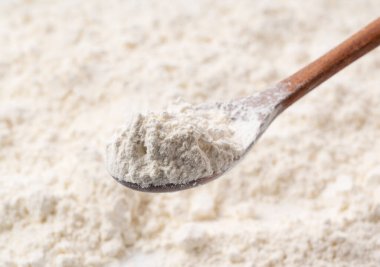 Un ve kepçelenmiş tahta kaşık yakın plan.