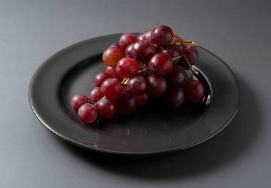 Kırmızı Küre, gri bir arkaplana karşı siyah bir plaka üzerinde servis edilmektedir..