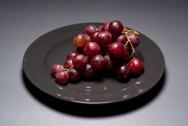 Kırmızı Küre, gri bir arkaplana karşı siyah bir plaka üzerinde servis edilmektedir..