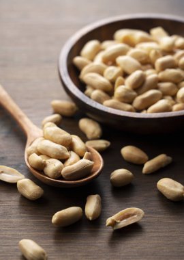 Tahta bir masada, tahta bir kasede yer fıstığı.