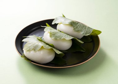 Kashiwa Mochi (pirinç keki) yeşil arka plana yerleştirildi. Kashiwa Mochi bir Japon şekerlemecisidir.
