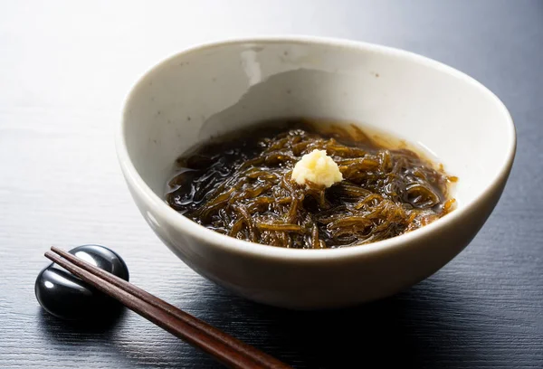 莫祖库海草放在黑色的背景上 莫祖库是冲绳的美食 这是一种用醋调味的深色线状海藻 — 图库照片
