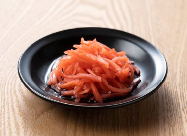 Red pickled ginger on a wooden table. Image of red pickled ginger in Japan.
