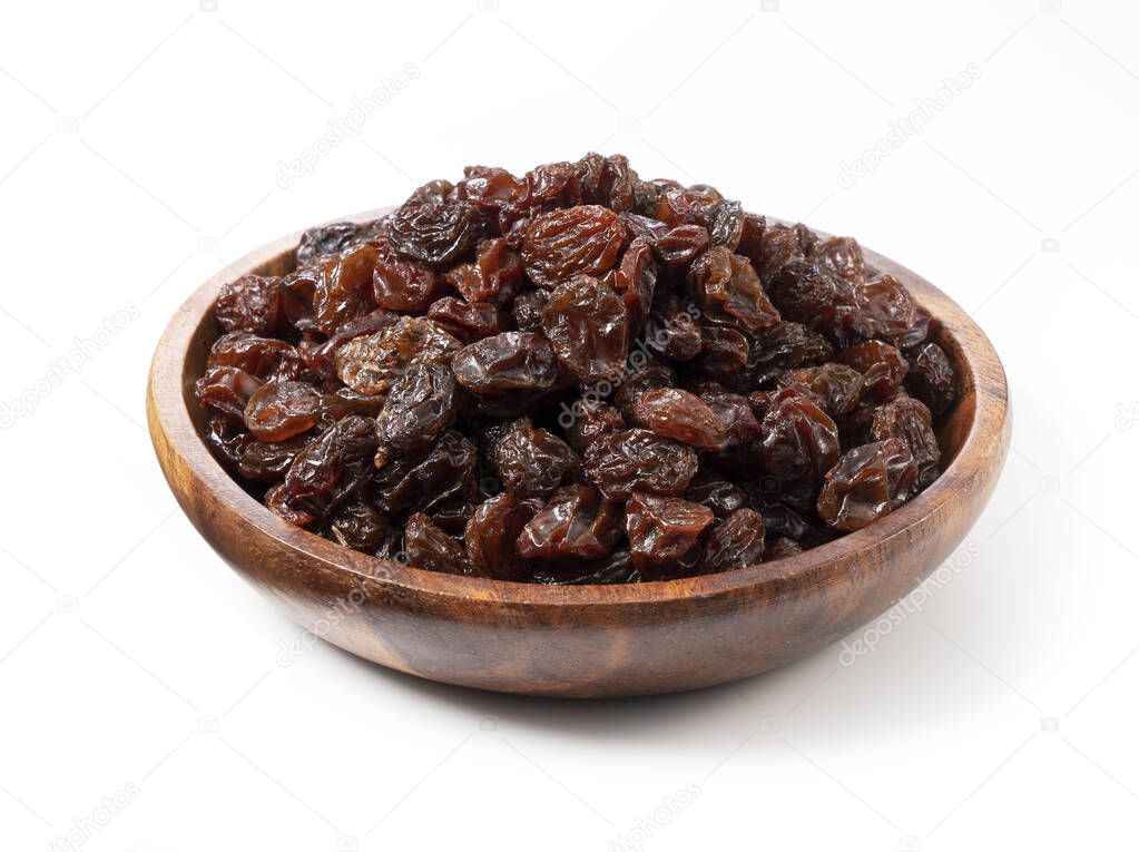 Raisins in a wooden bowl set against a white background.