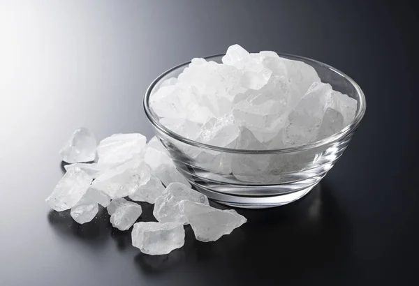 rock candy in a glass bowl set against a black background.