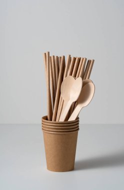 Kahverengi kullan-at kağıt bardaklar, pipetler ve kaşıklar beyaz arka planda. Sıfır atık kavramı. 