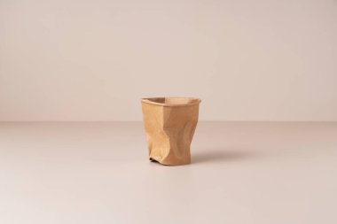 Bej arka planda ezilmiş tek kullanımlık kağıt bardak. Sıfır atık kavramı. 