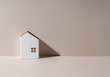 Bej arka planda fotokopi alanı olan bir evin modeli. Ev konsepti, ev satışı.