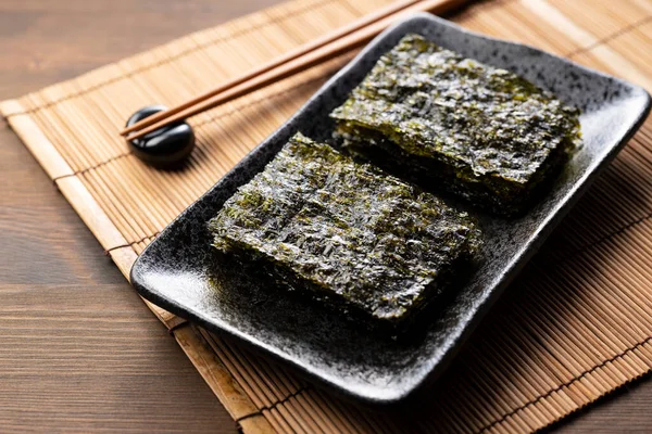 Korean seaweed served on a plate on a wooden table.