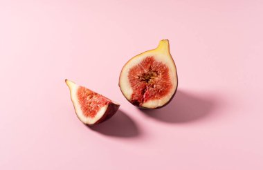 Pembe arka plana yerleştirilmiş incirler. İncir resmi.