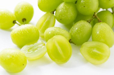 Beyaz arka planda bir sürü Shine-Muscat üzümü ve Shine-Muscat üzümü var. Beyaz üzümler. Japon üzümleri. 