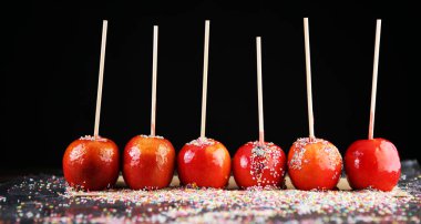 Tatlı kırmızı jöleli elma şekerlemeleri çiftçi pazarında ya da çocuklar ve ebeveynler için panayırda satılıyor.