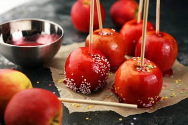 Tatlı kırmızı jöleli elma şekerlemeleri çiftçi pazarında ya da çocuklar ve ebeveynler için panayırda satılıyor.