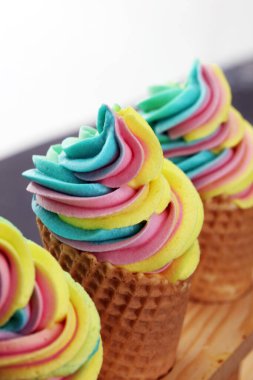 Vanilyalı donmuş yoğurt ya da waffle külahında gökkuşağı dondurması.