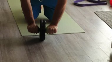 Oturma odasında adam covid nedeniyle ab roller kullanıyor. 