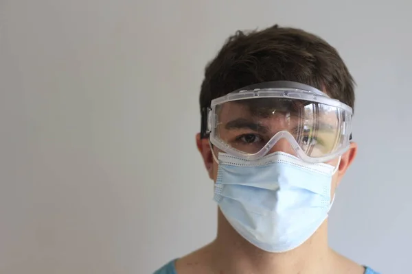 Man in face medical surgical mask with transparent shield mask and gloves.