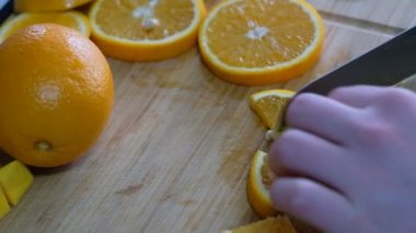 Smoothie 'ye hazırlamak için kesme tahtasından portakal kesmek