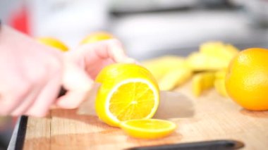 Smoothie 'ye hazırlamak için kesme tahtasından portakal kesmek