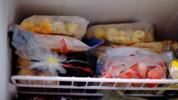Вытаскивание замороженных фруктов из морозилки — стоковое видео