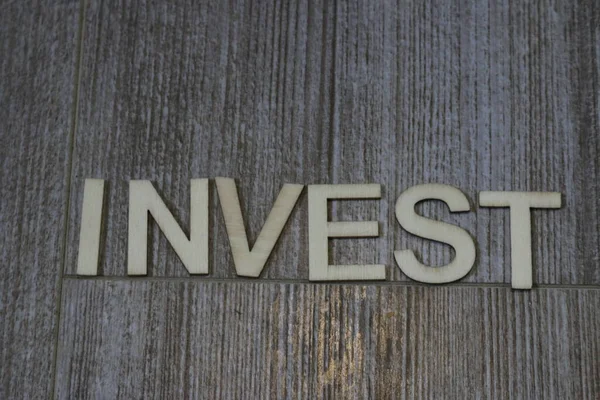 Ordet invest skrev på kakel tema — Stockfoto