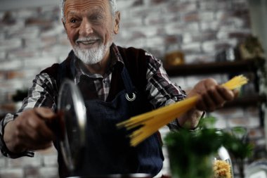 Mutlu son sınıf öğrencisi elinde spagetti ve gülümsüyor.