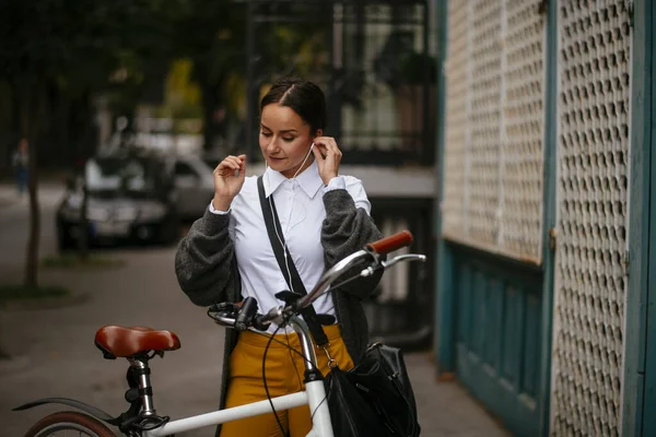 Bisikletin Yanında Duran Genç Bir Kadın Kulaklık Takıyor — Stok fotoğraf
