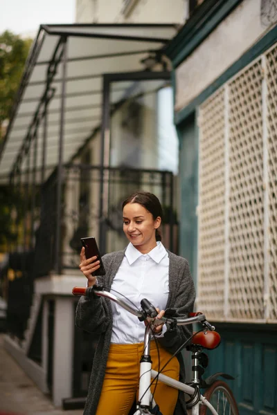 Gülümseyen Kadın Akıllı Telefon Ekranına Bakıyor Bisiklet Tutuyor — Stok fotoğraf