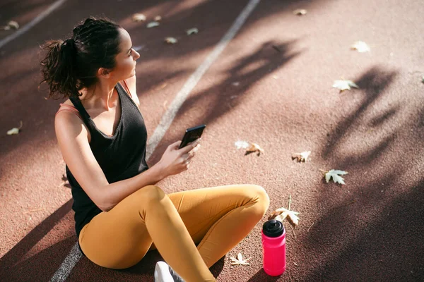 Perempuan Dalam Pakaian Sportif Duduk Trek Berjalan Dan Menggunakan Smartphone — Stok Foto