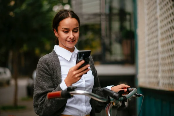 Gülümseyen Kadın Akıllı Telefon Ekranına Bakıyor Bisiklet Tutuyor — Stok fotoğraf