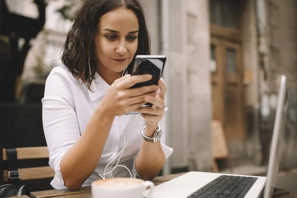 Wanita Dengan Smartphone Tangan Menggunakan Earphone Laptop Dan Cangkir Kopi — Stok Foto