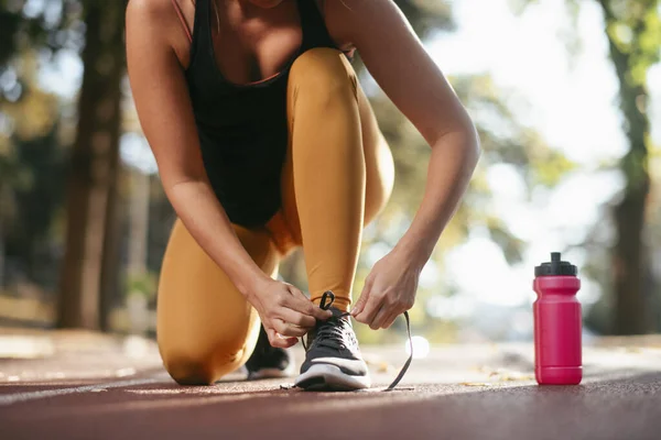 Potret Wanita Mengikat Tali Sepatu Pelatih Dengan Botol Air Tanah — Stok Foto