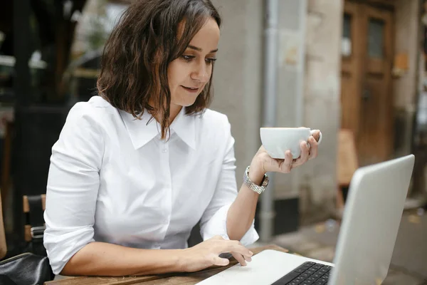 Woman Using Laptop While Holding Coffee Cup Outdoor Cafe Table — Stock Photo, Image