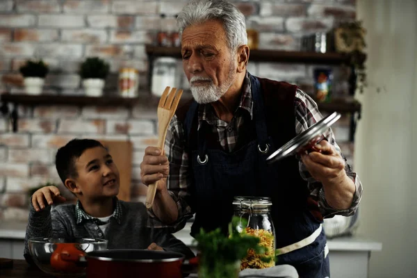 Vovô Feliz Neto Cozinhar Cozinha Homem Olhando Para Espátula Madeira — Fotografia de Stock