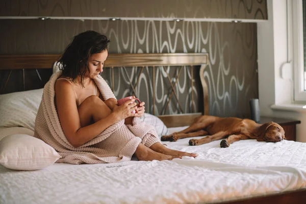 Mujer Joven Sosteniendo Taza Cama Con Perro Dormido — Foto de Stock