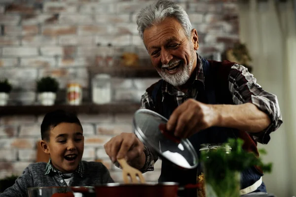爷爷和孙子快乐地在厨房做饭 在平底锅里搅拌 — 图库照片