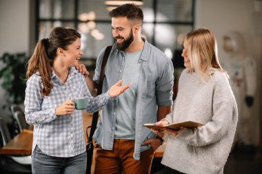 Modern açık uzay ofisinde sıradan iş adamlarından oluşan bir grup. İş kadınları ve işadamları yeni proje hakkında konuşuyor.