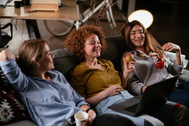 Ofiste konuşan ve gülen kızlar. Ofiste kahve içen güzel kadınlar