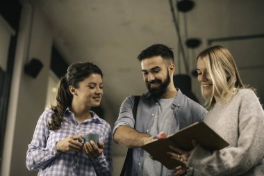Modern açık uzay ofisinde sıradan iş adamlarından oluşan bir grup. İş kadınları ve işadamları yeni proje hakkında konuşuyor.
