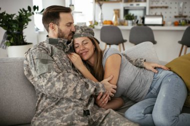 Mutlu asker evde karısına sürpriz yapıyor. Genç asker karısını kucaklıyor..
