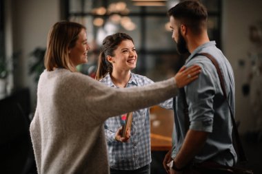 Modern açık uzay ofisinde sıradan iş adamlarından oluşan bir grup. İş kadınları ve işadamları yeni proje hakkında konuşuyor.