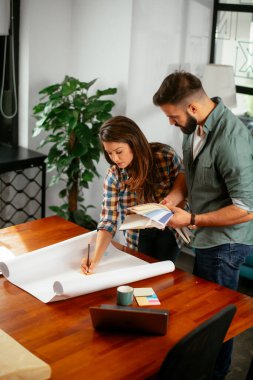 Meslektaşlar modern ofisteki konferans odasında toplantı yapıyorlar.